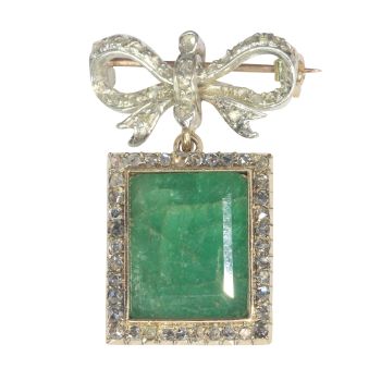 Antique Victorian diamond bow brooch with large emerald pendant hanging underneath by Unknown artist
