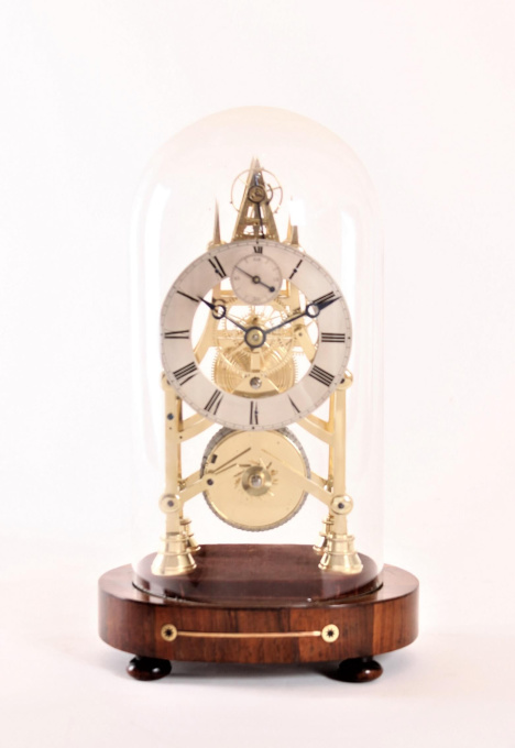 A small English brass skeleton clock with balance wheel, circa 1840 by Artiste Inconnu